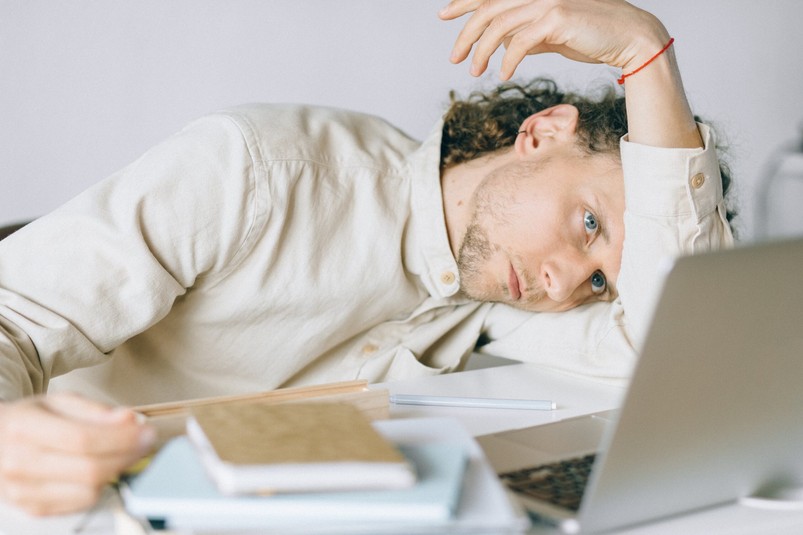 Ein Mann lehnt verzweifelt über seinem Arbeitsplatz - er will so nicht mehr weiter machen